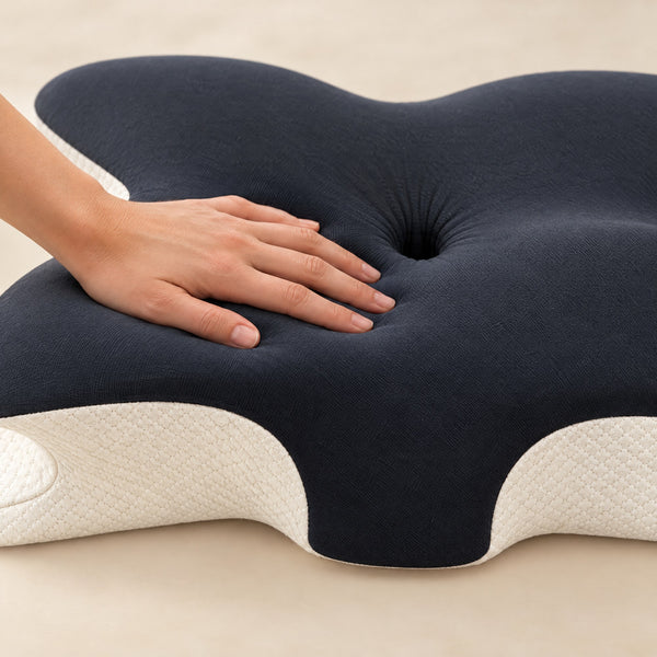 A hand pressing into the Dark Grey pillow's memory foam